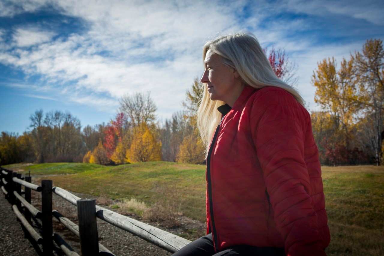 25 Oct 2014 --- Older Caucasian woman sitting on wooden fence --- Image by © Steve Smith/Blend Images/Corbis