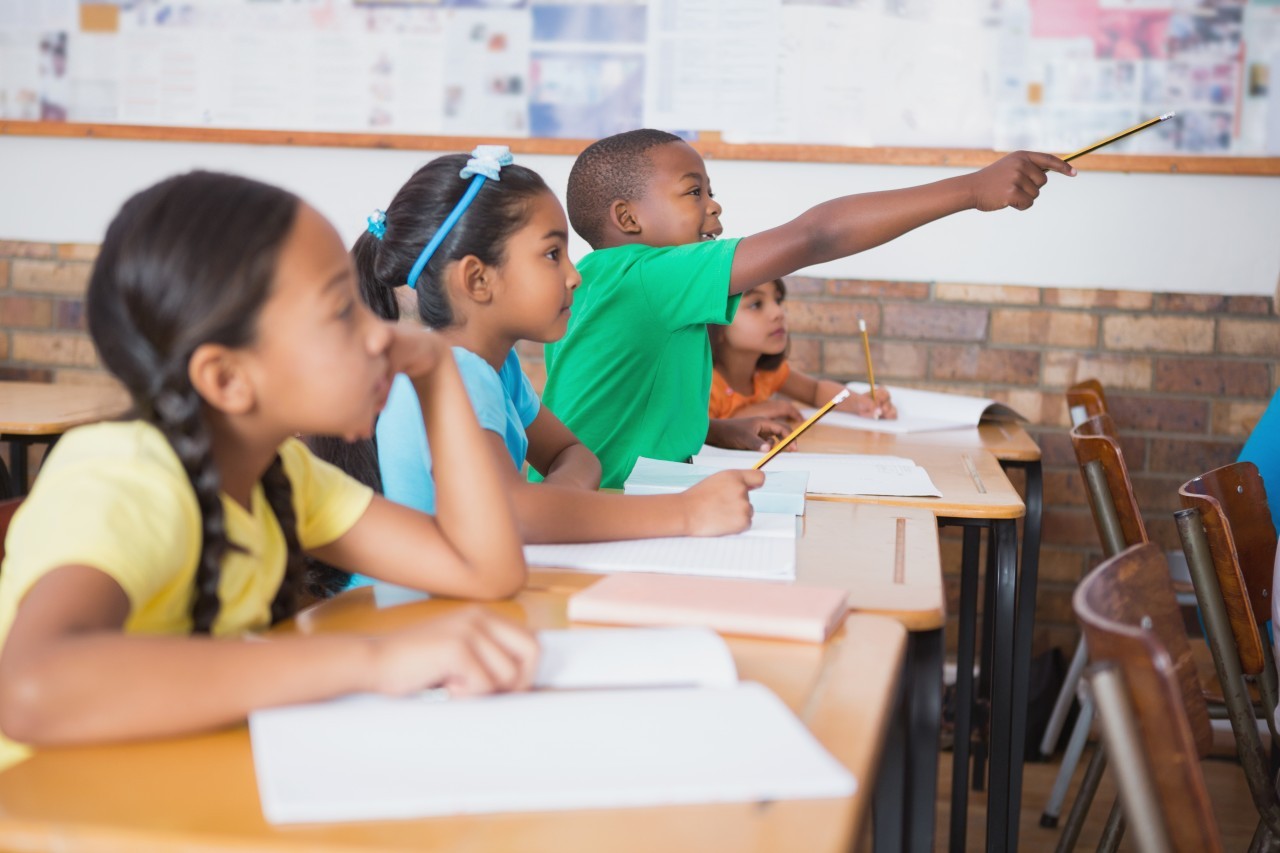 11 May 2014 --- Cute pupil raising hand in classroom --- Image by © Wavebreak Media LTD/Wavebreak Media Ltd./Corbis