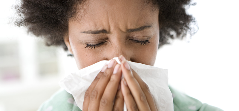 Woman Blowing Her Nose --- Image by © Michael A. Keller/Corbis