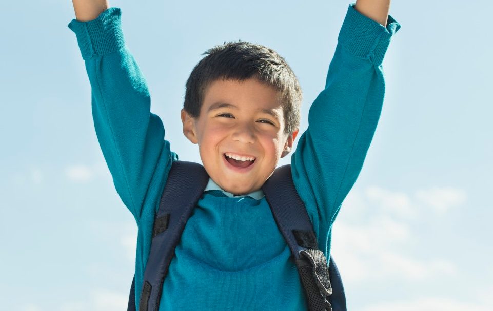 Boy (6-7) wearing backpack punching air --- Image by © Tetra Images/Corbis