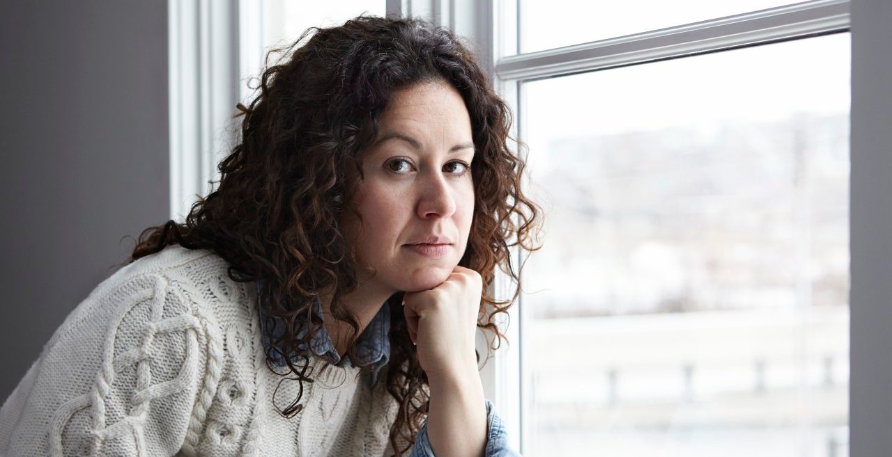 Portrait of woman thinking by window --- Image by © Darren Kemper/Corbis