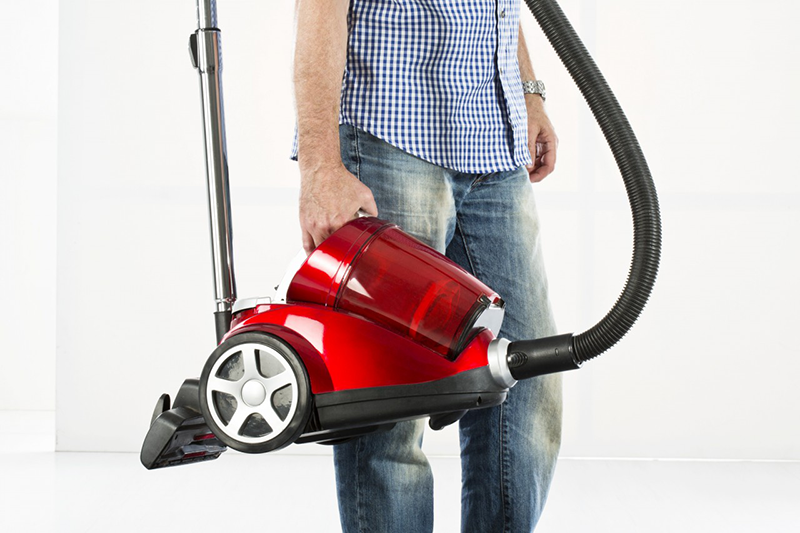 05 May 2013 --- Mature man holding vaccuum cleaner --- Image by © Roman Märzinger/Westend61/Corbis