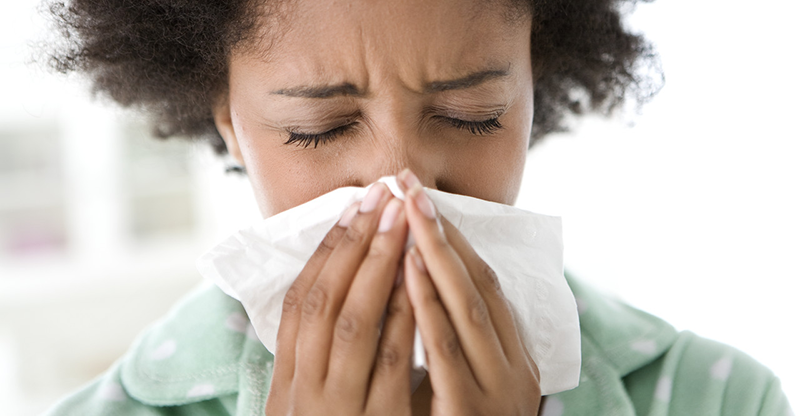 42-21529108 Woman Blowing Her Nose --- Image by © Michael A. Keller/Corbis