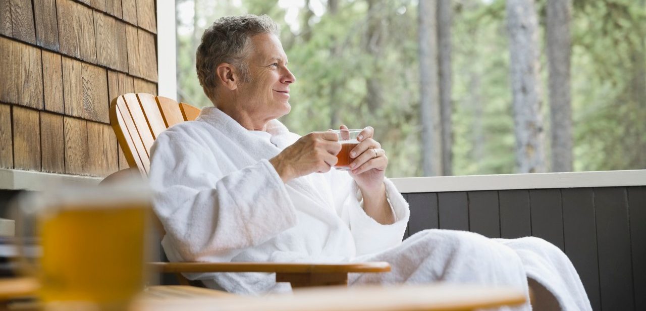 04 Jul 2013 --- Man relaxing on porch with a cup of tea --- Image by © Hero Images/Corbis