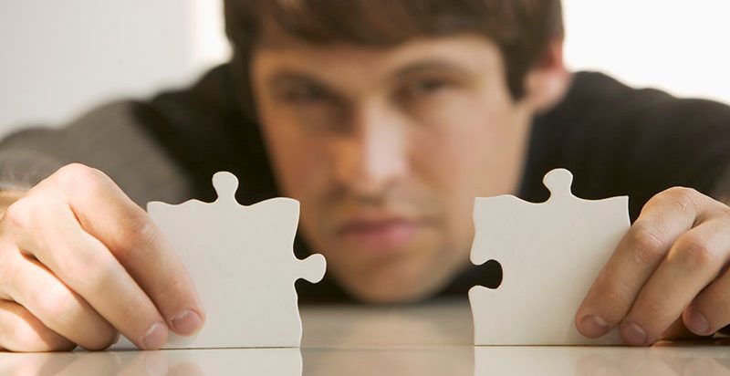 Man with puzzle pieces --- Image by Â© Tetra Images/Corbis