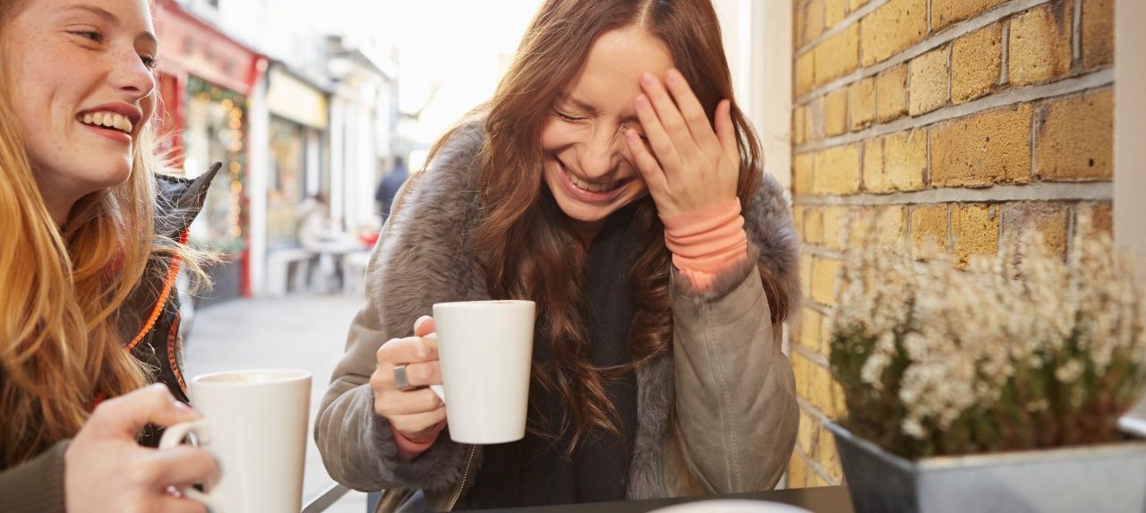 0042-11-30T00:00:00.000Z Two female friends sitting in sidewalk cafe laughing --- Image by © Emma Tunbridge/Corbis