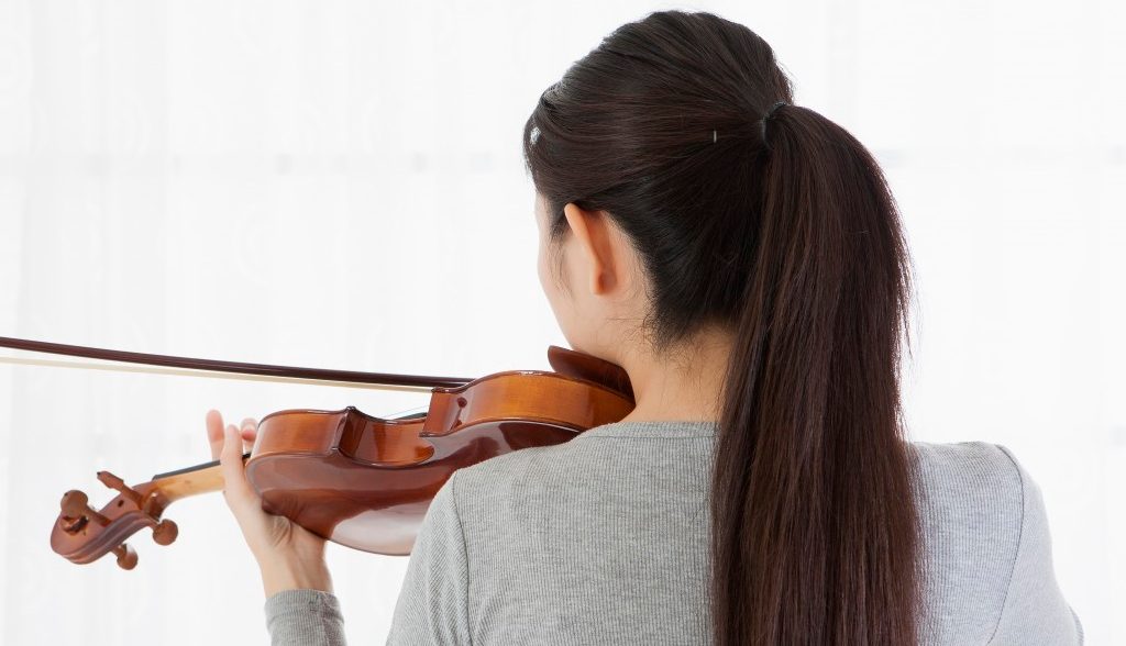 15 Oct 2014 --- Young woman playing violin with rear view --- Image by © IMAGEMORE M/Imagemore Co., Ltd./Corbis
