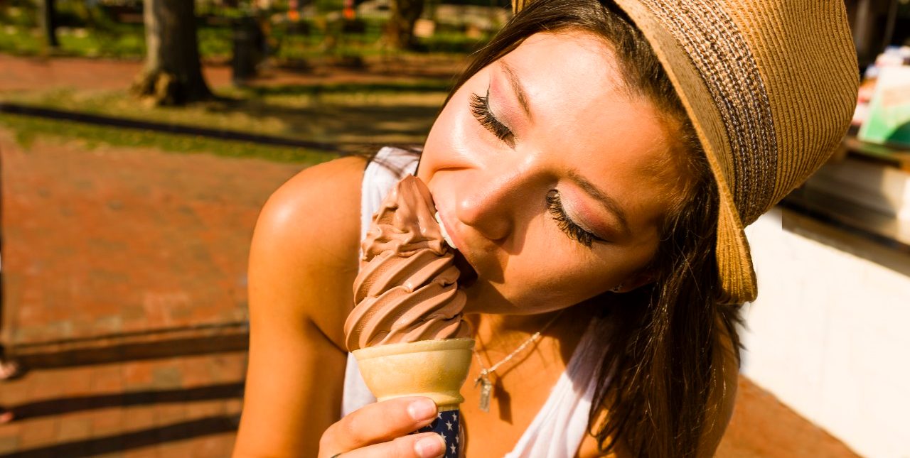 27 Aug 2014 --- Young woman eating ice cream cone in park --- Image by © Zave Smith/Corbis