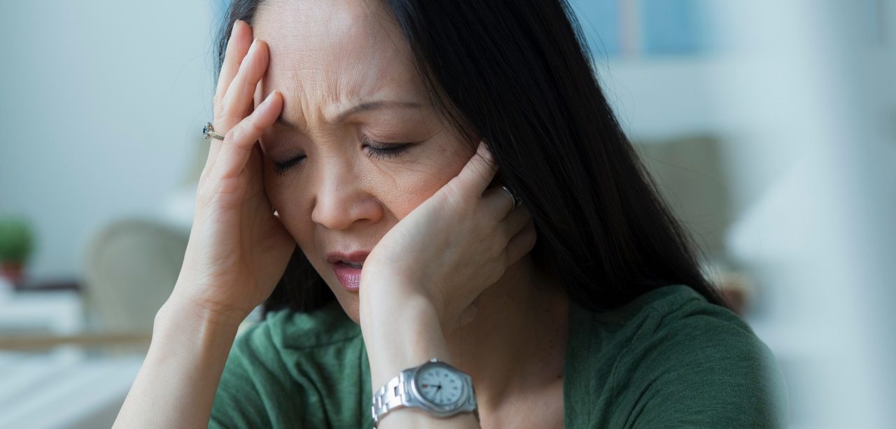 Mature woman with head in hands --- Image by © Rob Lewine/Corbis