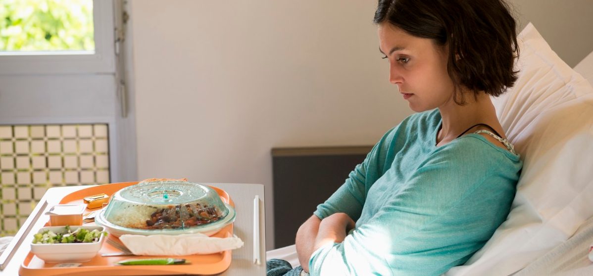 Anorexia nervosa patient with a food tray in hospital ward --- Image by © Eric Audras/Onoky/Corbis