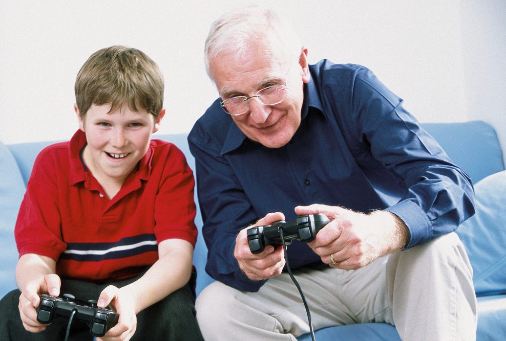 Child playing video games with grandfather