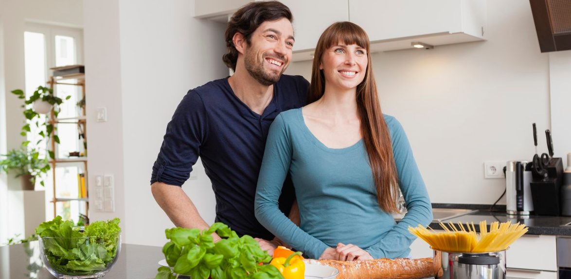 28 Oct 2014 --- Happy couple in kitchen --- Image by © Jo Kirchherr/Westend61/Corbis