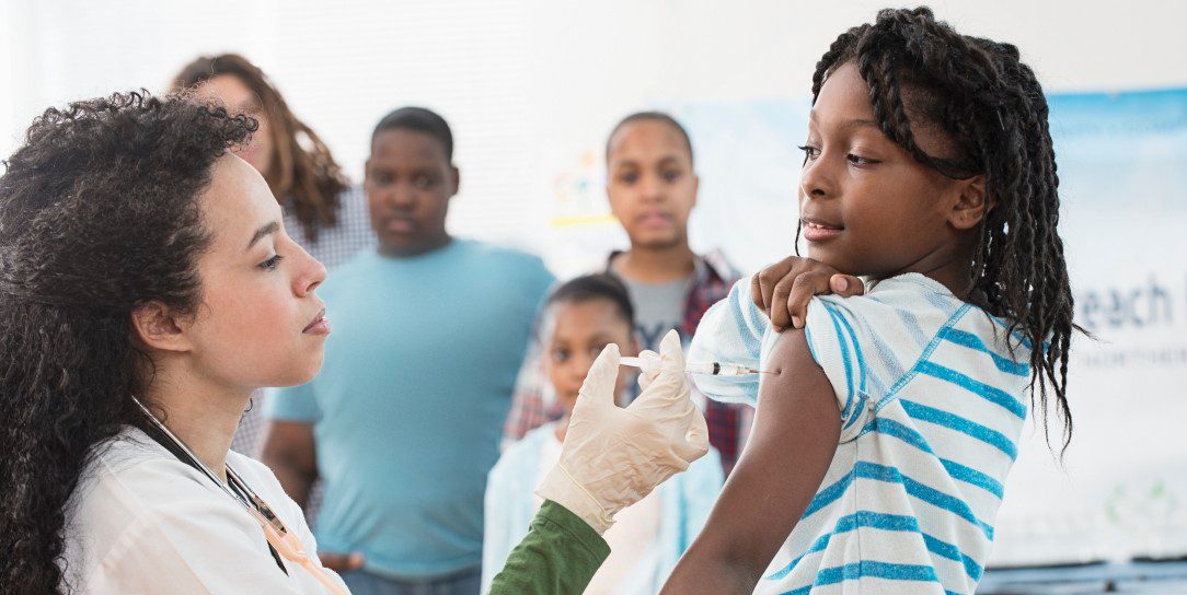 Girl (8-9) being vaccinated --- Image by © Jose Luis Pelaez/Corbis