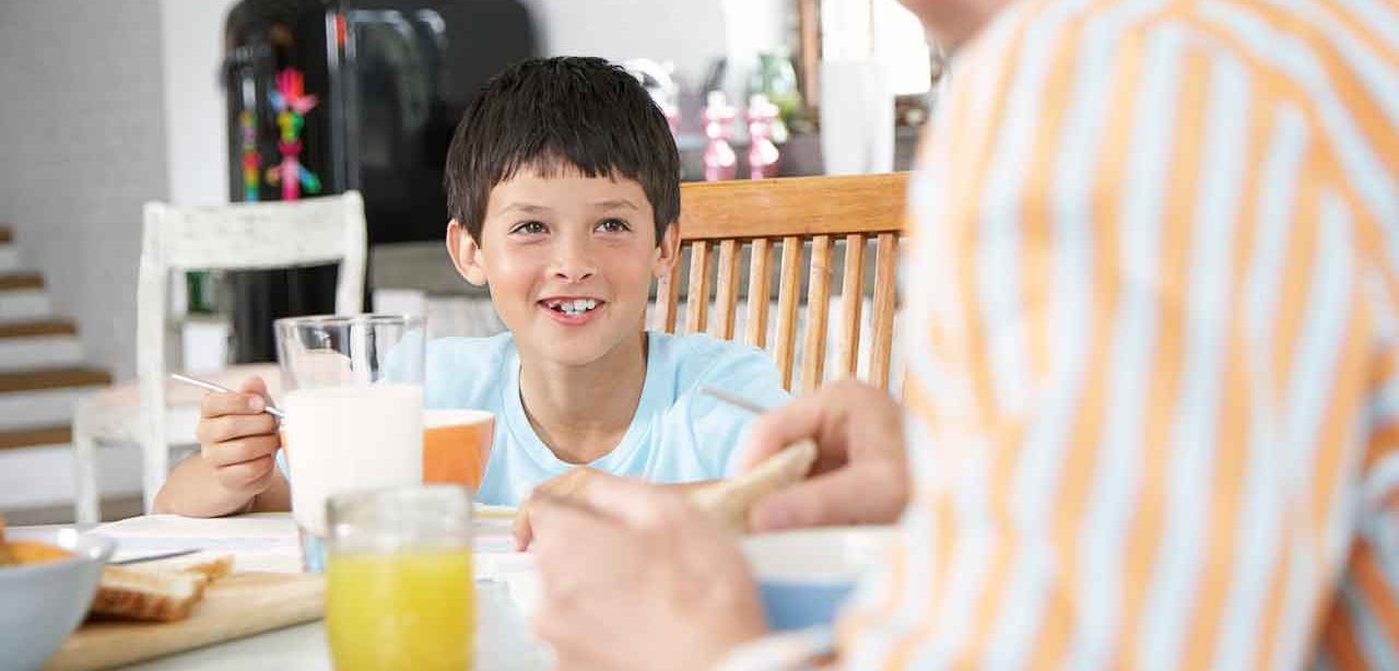 A child smiling eating breakfast