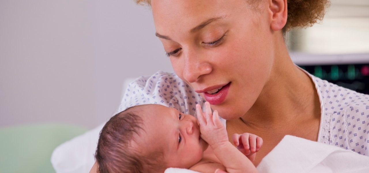 01 Jun 2012, Richmond, Virginia, USA --- Mixed race mother holding newborn baby --- Image by © Ariel Skelley/Blend Images/Corbis