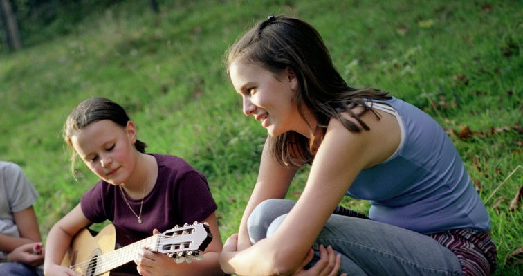 0042-11-30T00:00:00.000Z Three Girls Sitting with Guitar in Meadow --- Image by © Mika/Corbis