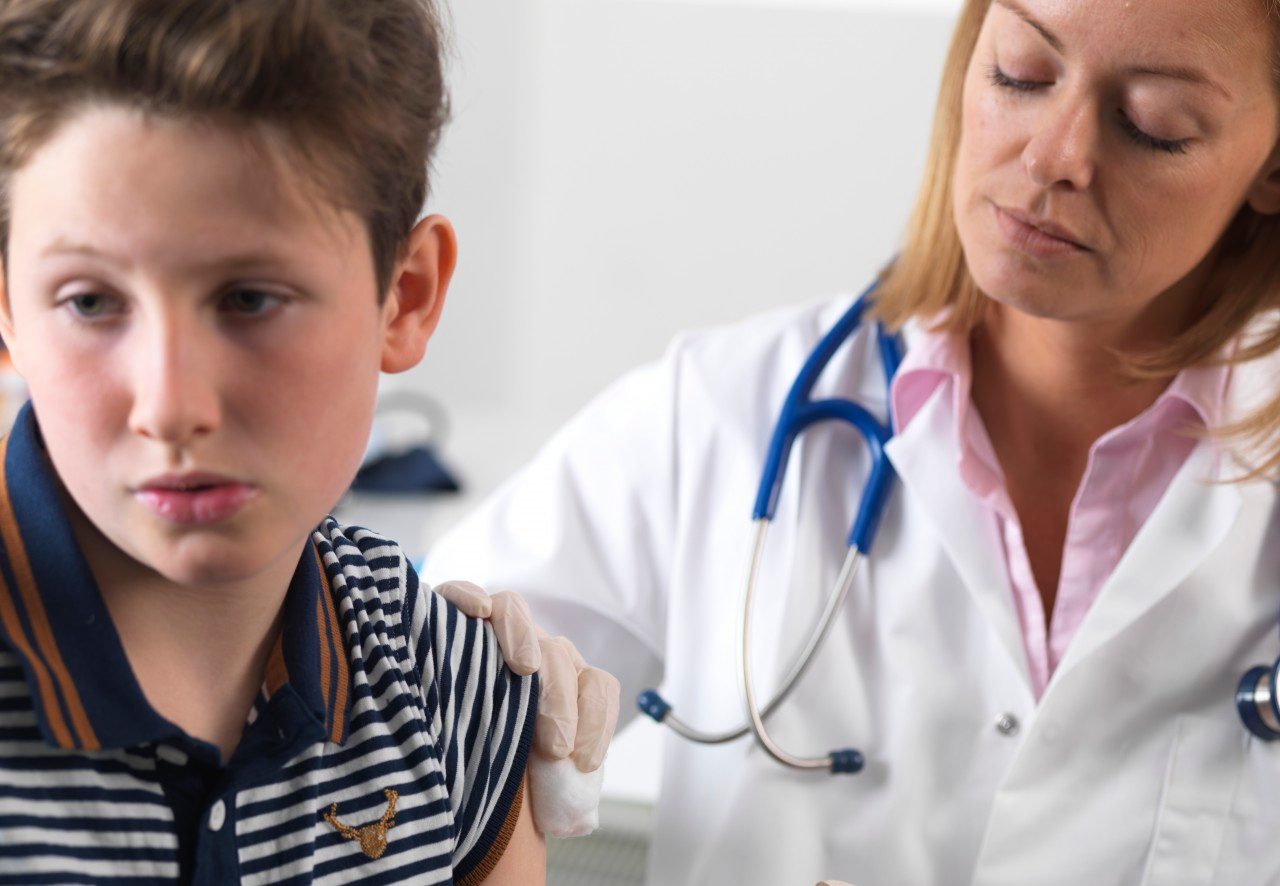 28 May 2015 --- Doctor injecting 10 year old boy a drug in a clinic. --- Image by © TEK IMAGE/Science Photo Library/Corbis