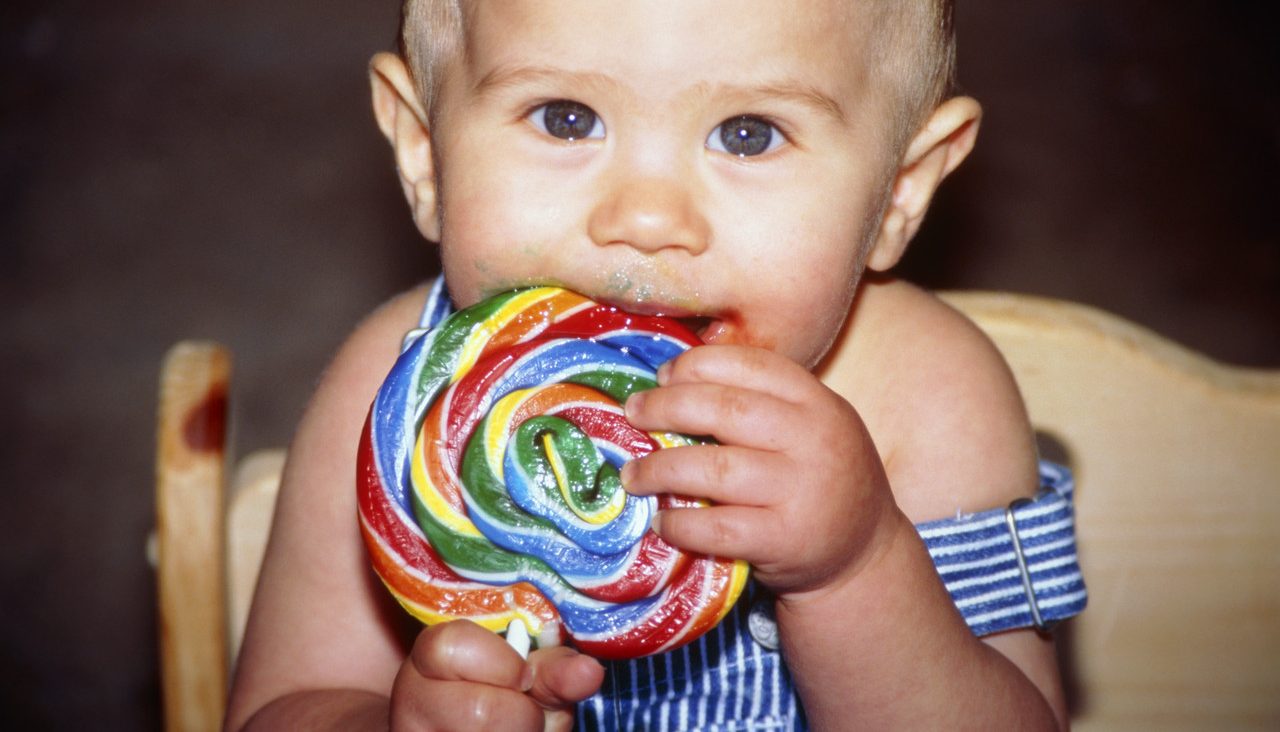 Baby Eating a Big Lollipop --- Image by © KG-Photography/Corbis