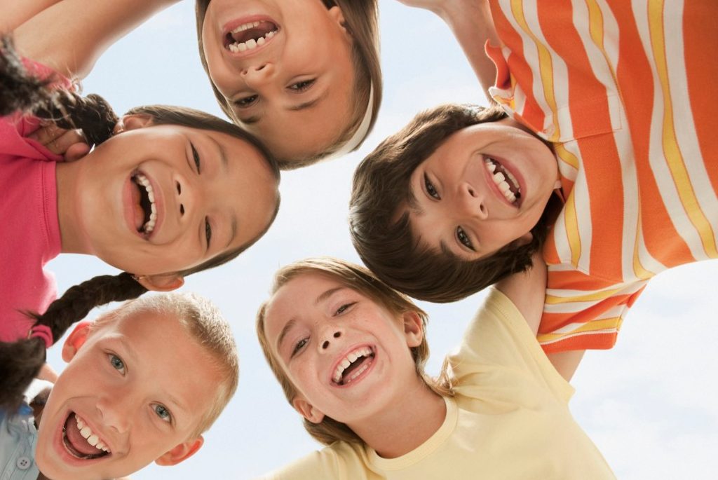 0042-11-30T00:00:00.000Z West New York, New Jersey, USA --- Smiling children huddling together --- Image by © KidStock/Blend Images/Corbis