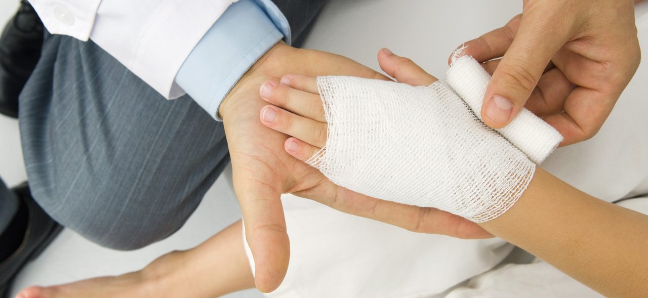 Doctor Wrapping a Patient's Hand in Gauze,high Angle View --- Image by © Odilon Dimier/PhotoAlto/Corbis