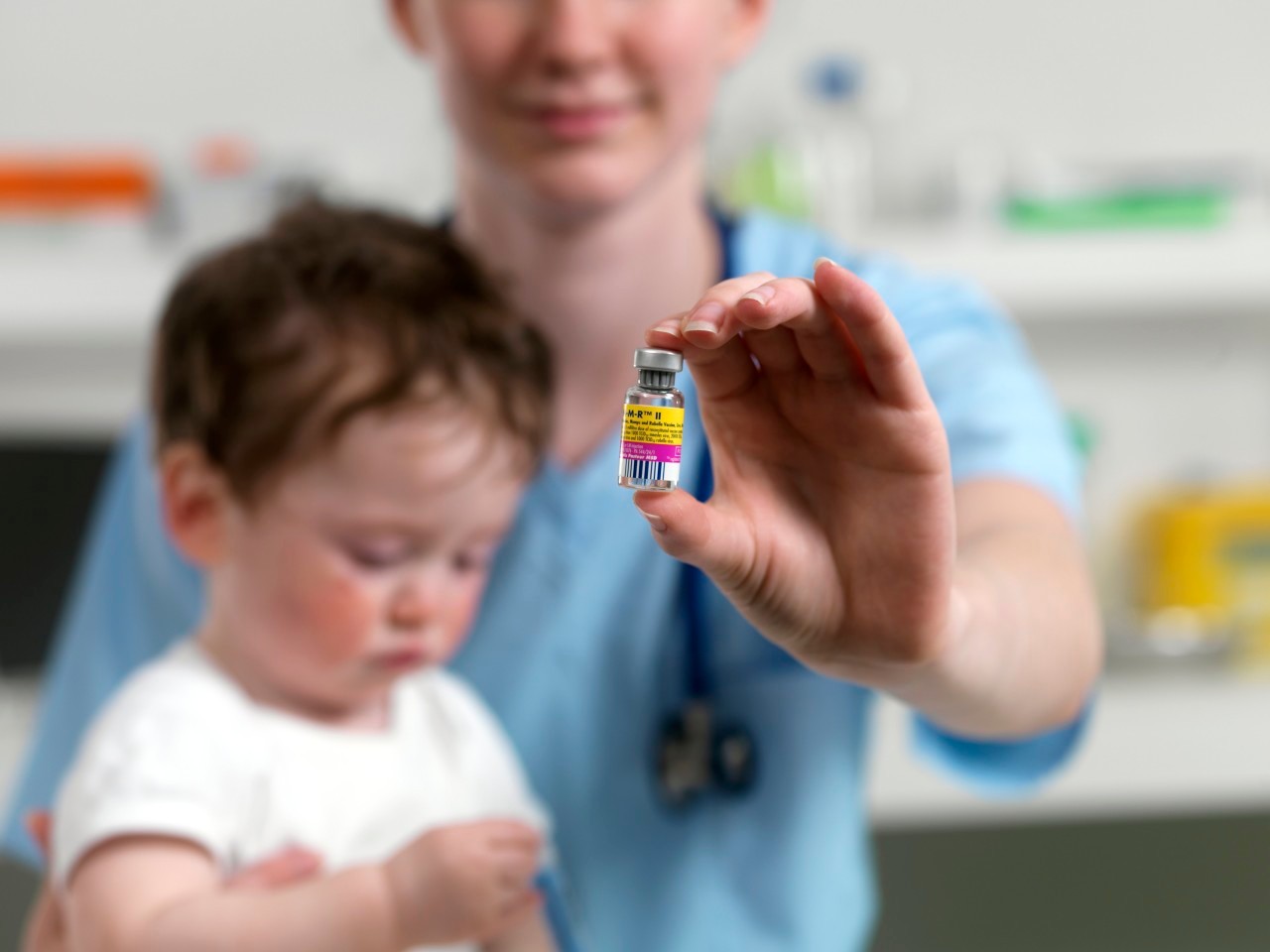 24 Aug 2010 --- MMR vaccine. Paediatrician with a phial of MMR vaccine and a 15 month old boy. --- Image by © TEK IMAGE/Science Photo Library/Corbis