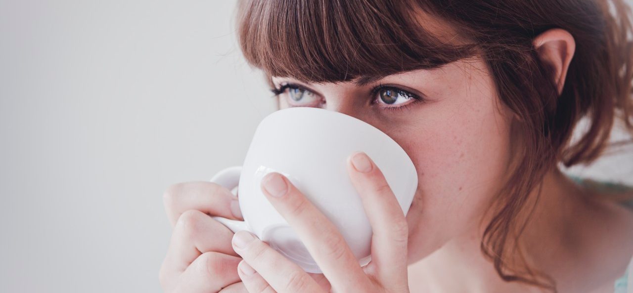 Young woman drinking tea --- Image by © Hannah Mentz/Corbis