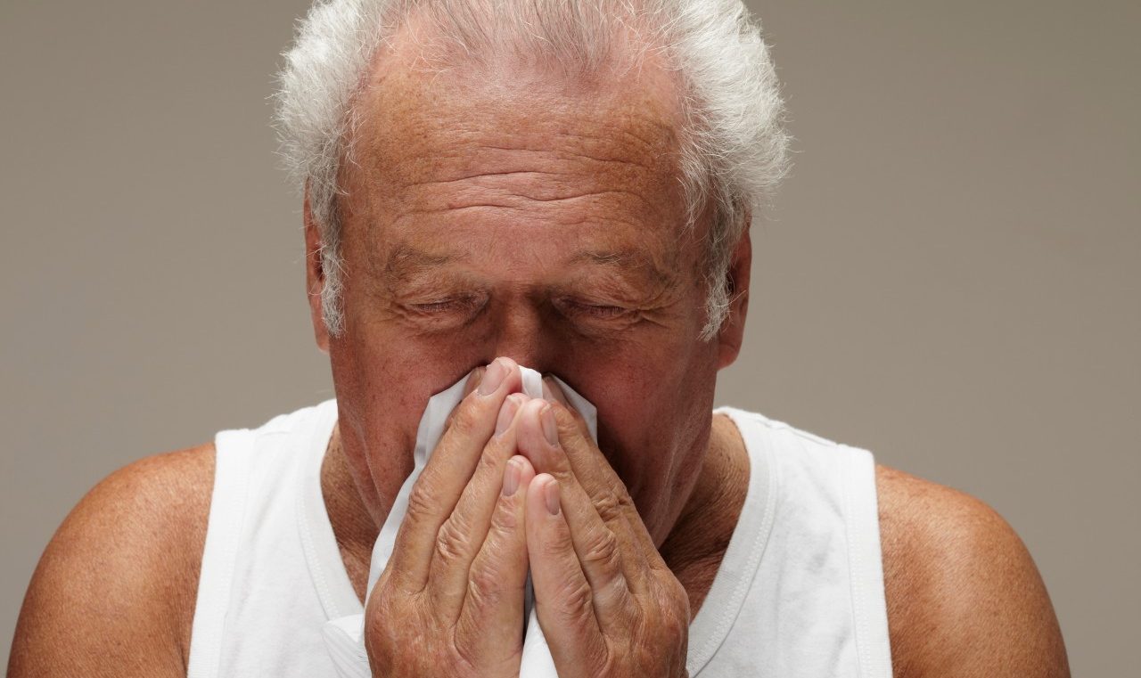 Senior man blowing nose --- Image by © Nick White/Image Source/Corbis