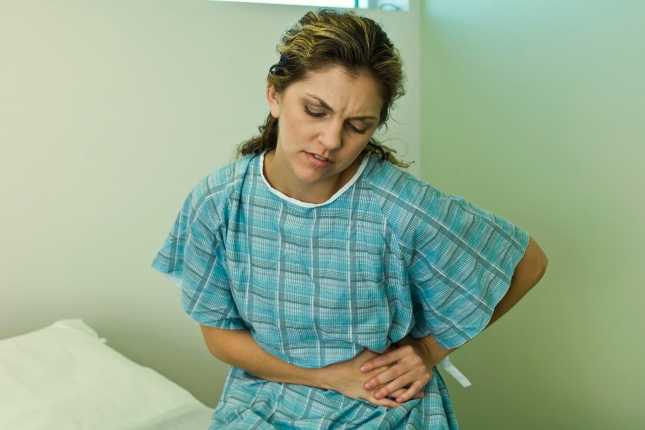 Female patient experiencing severe abdominal pain --- Image by © Michele Constantini/PhotoAlto/Corbis
