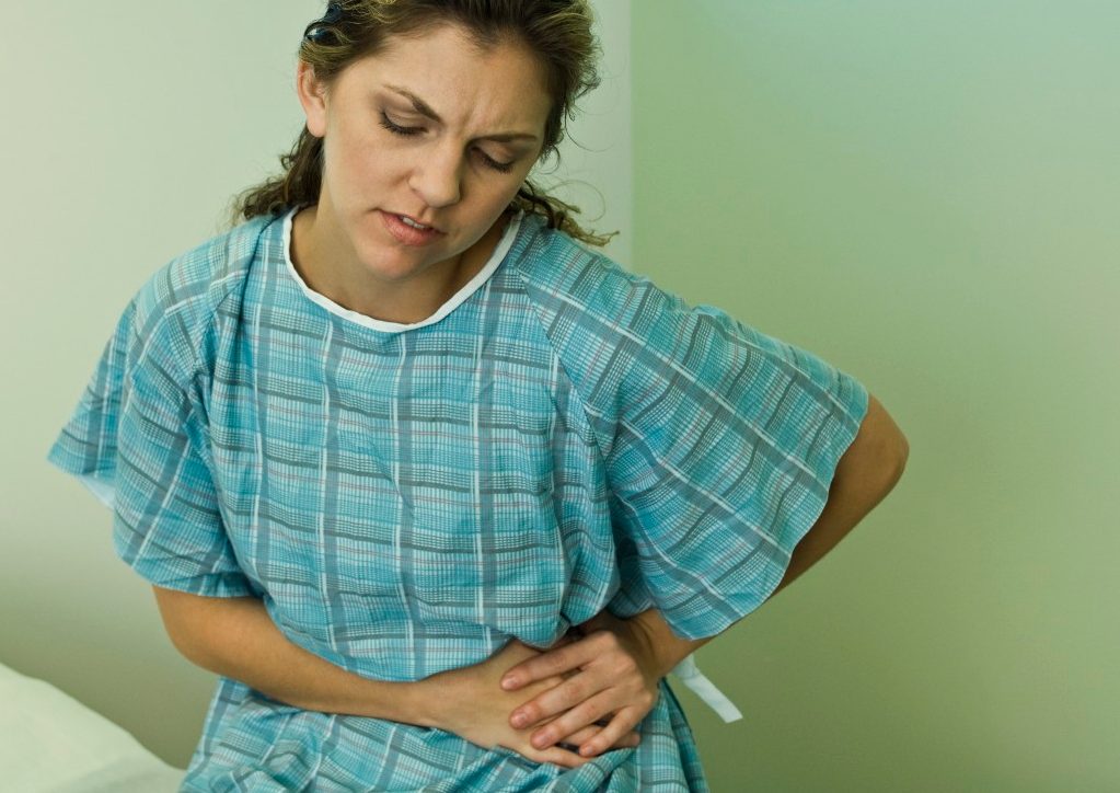 0042-11-30T00:00:00.000Z Female patient experiencing severe abdominal pain --- Image by © Michele Constantini/PhotoAlto/Corbis