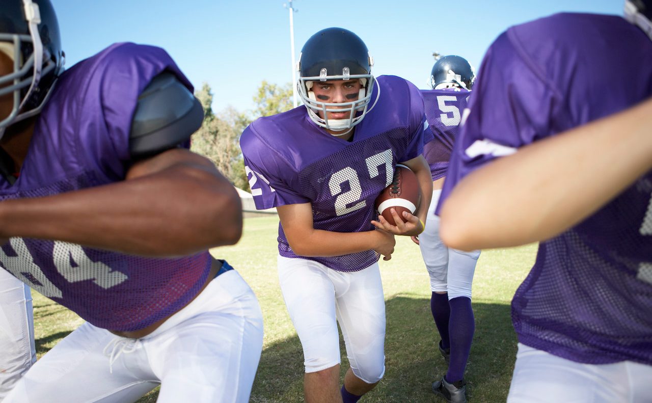 Running Back behind Linemen --- Image by © moodboard/Corbis