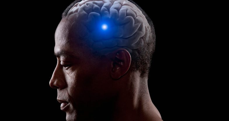 Blue light shining from brain of mixed race man --- Image by © John Lund/Blend Images/Corbis
