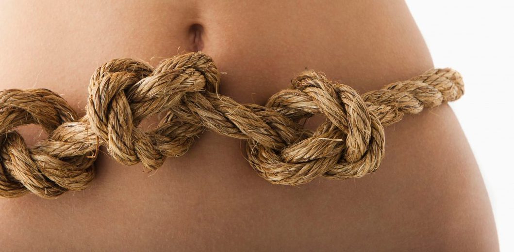 Young woman with knots in stomach --- Image by Â© Mike Kemp/Tetra Images/Corbis
