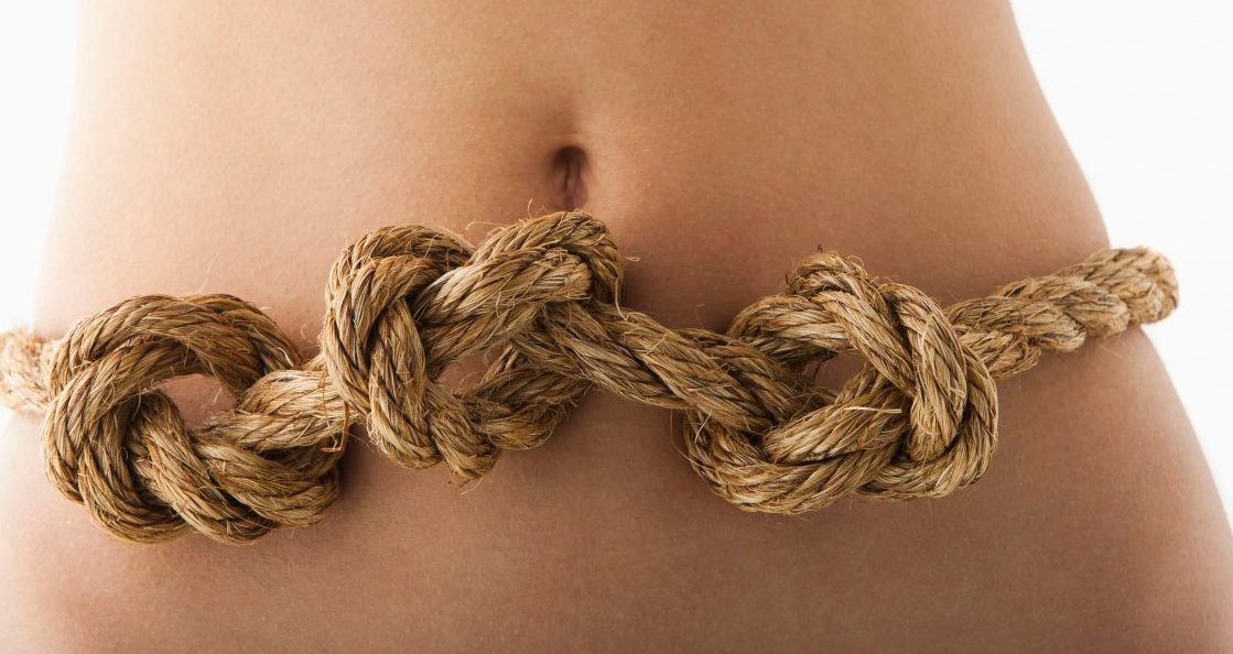 Young woman with knots in stomach --- Image by Â© Mike Kemp/Tetra Images/Corbis