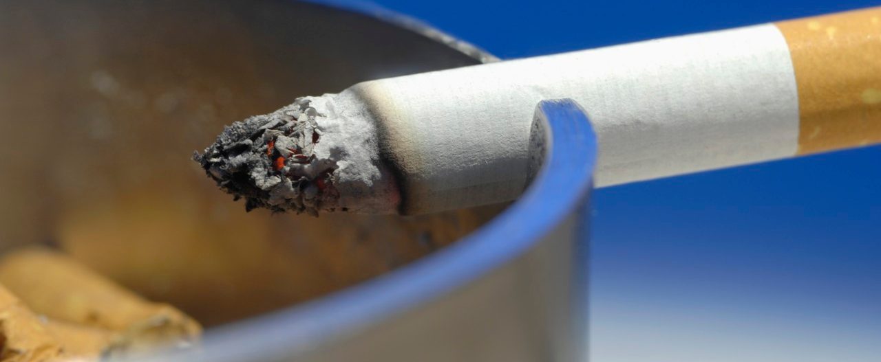 Cigarette on ashtray, close up --- Image by © Claudia Rehm/Westend61/Corbis