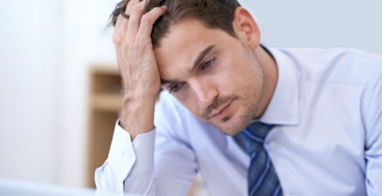 Man holding his head in his hand