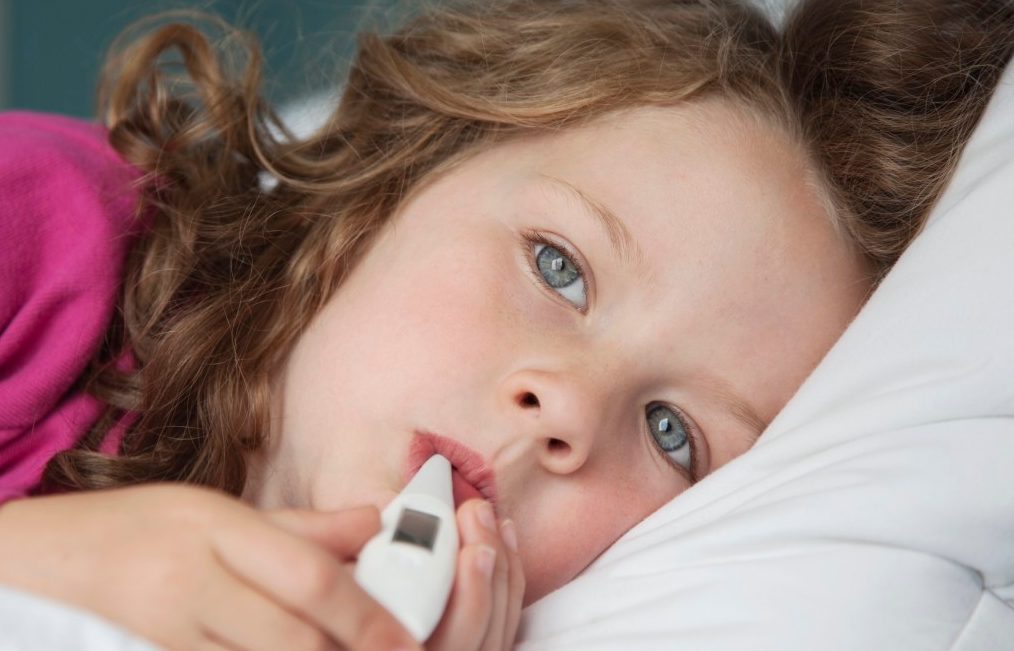Thermometer in sick girl's mouth --- Image by © Patrick Lane Photography/Corbis