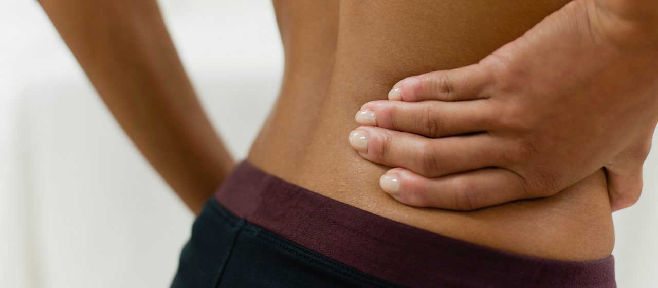 0042-11-30T00:00:00.000Z Woman with hand on lower back, mid section --- Image by © Odilon Dimier/PhotoAlto/Corbis