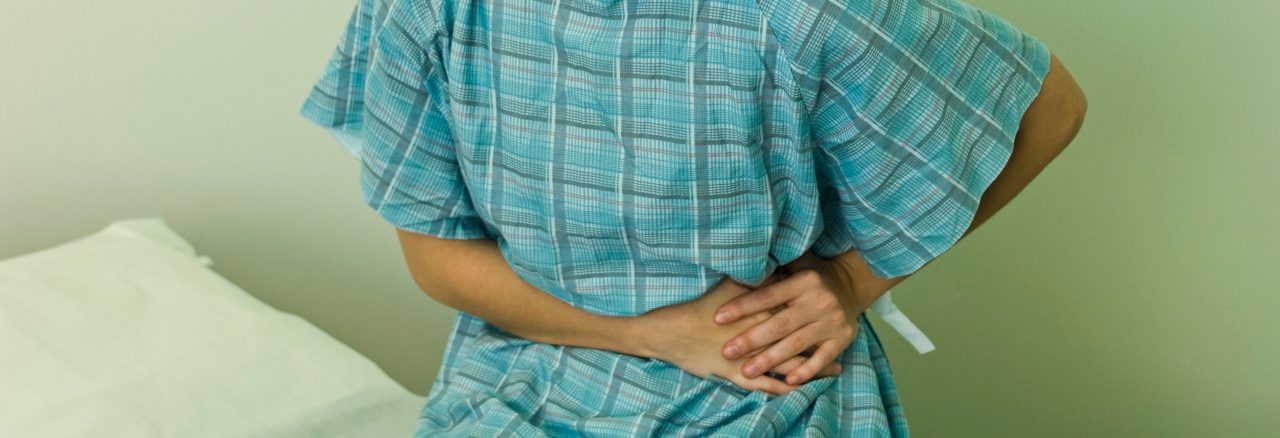 Female patient experiencing severe abdominal pain --- Image by © Michele Constantini/PhotoAlto/Corbis