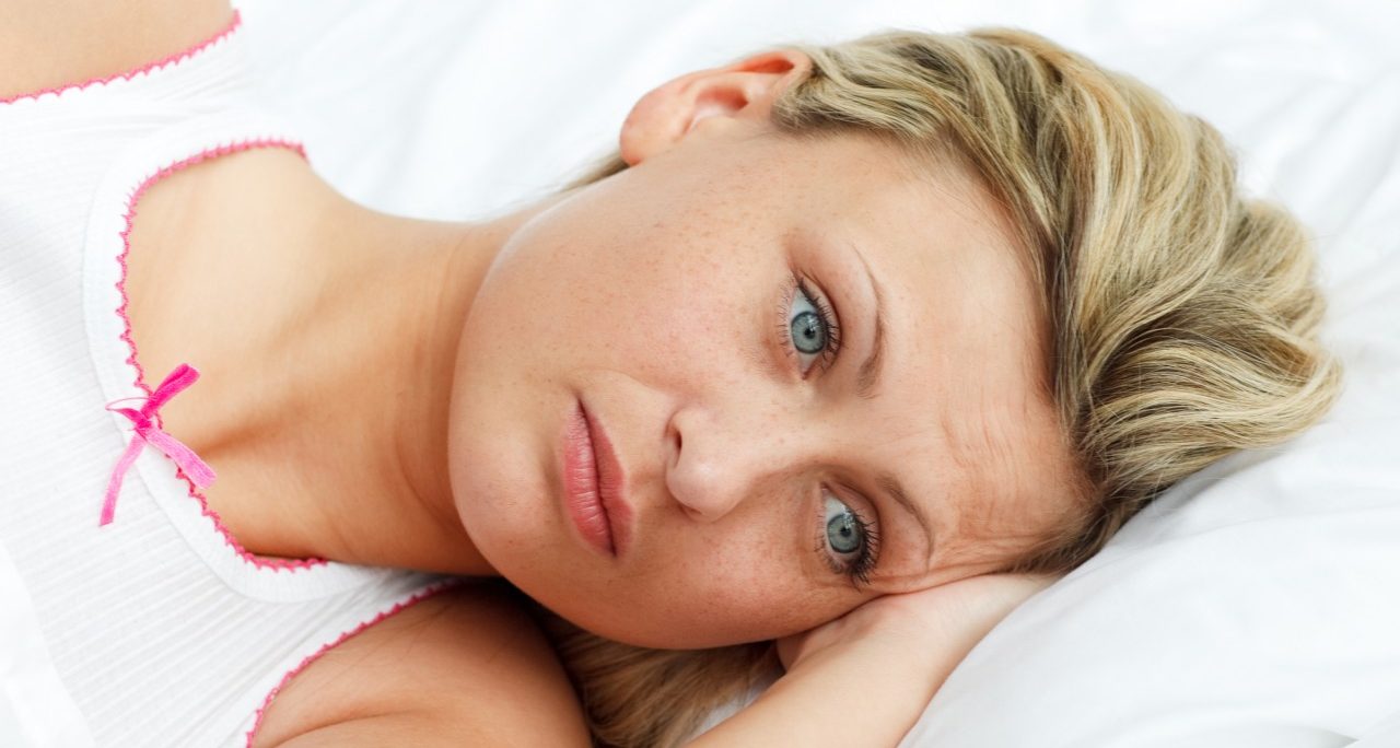 Portrait of upset woman lying in bed --- Image by © Wavebreak Media Ltd/Veer/Corbis