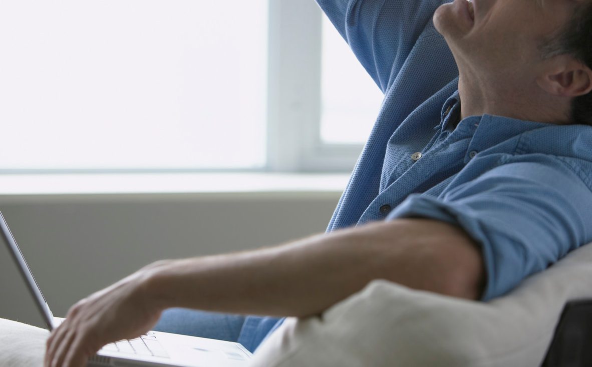 Stressed Businessman with Laptop on Sofa --- Image by © LWA-Dann Tardif/Corbis