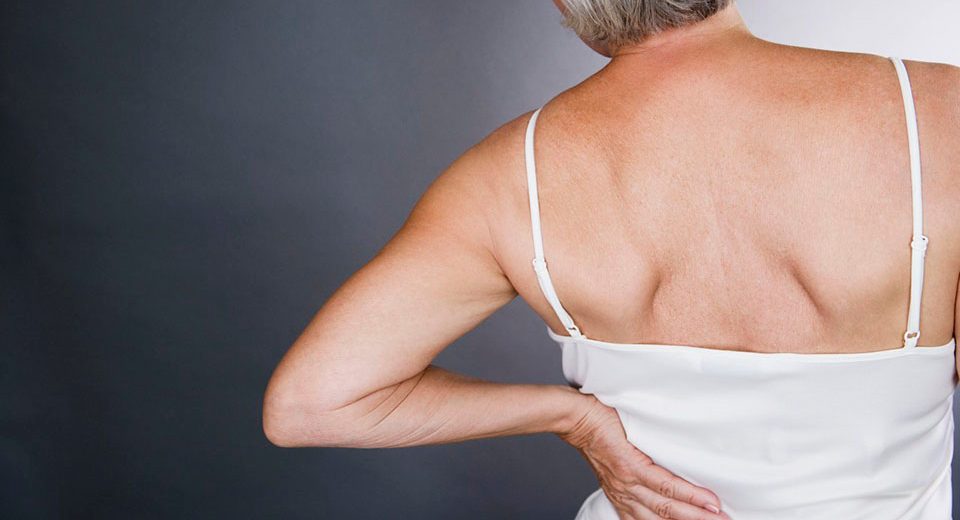 A senior woman with backache --- Image by Â© I Love Images/Corbis