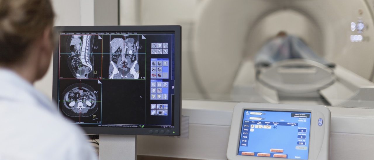 Doctor operating CT scanner in hospital --- Image by © Hybrid Images/cultura/Corbis