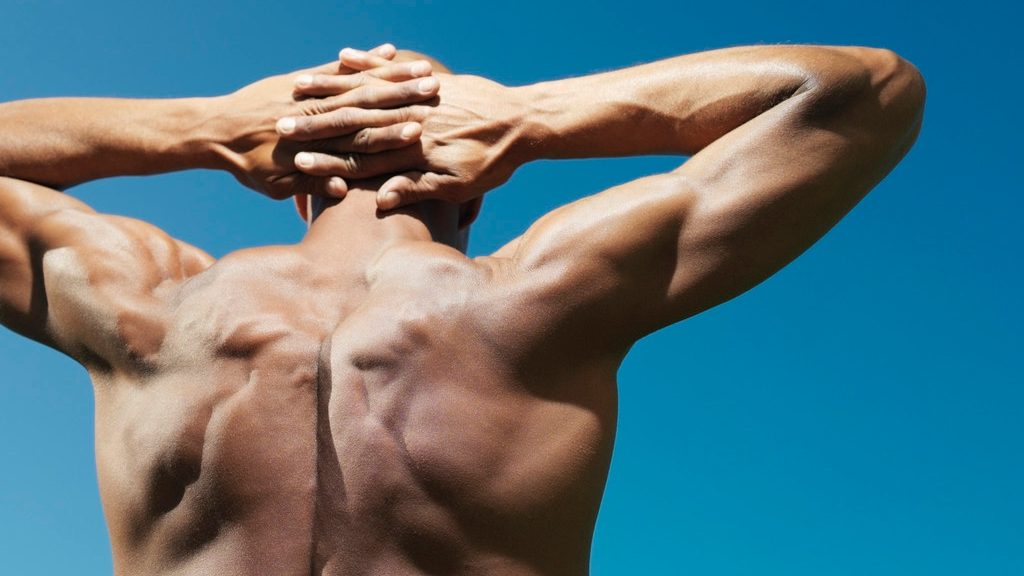 Muscular man with hands behind head --- Image by © Bernd Vogel/Corbis