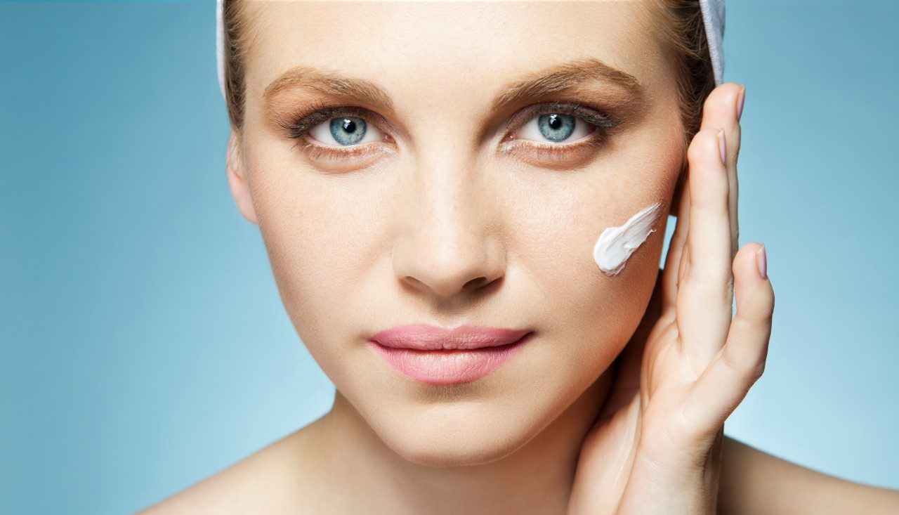 Woman applying moisturiser --- Image by © Innocenti and Lee/Image Source/Corbis