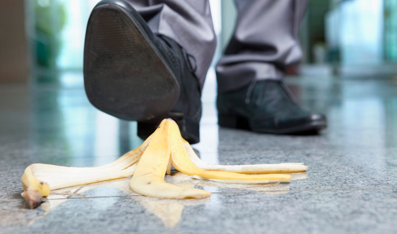 Businessman stepping on banana peel --- Image by © Juice Images/Corbis