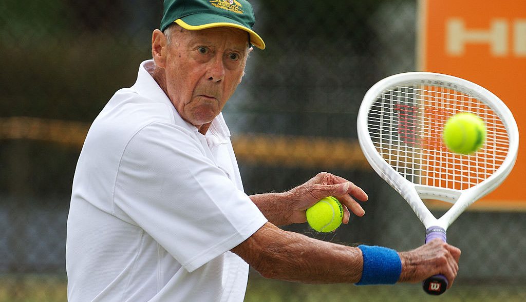 An older man playing tennis