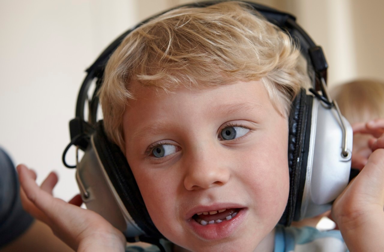 31 Jan 2015 --- Little boy listening to music with headphones --- Image by © Rainer Holz/Westend61/Corbis