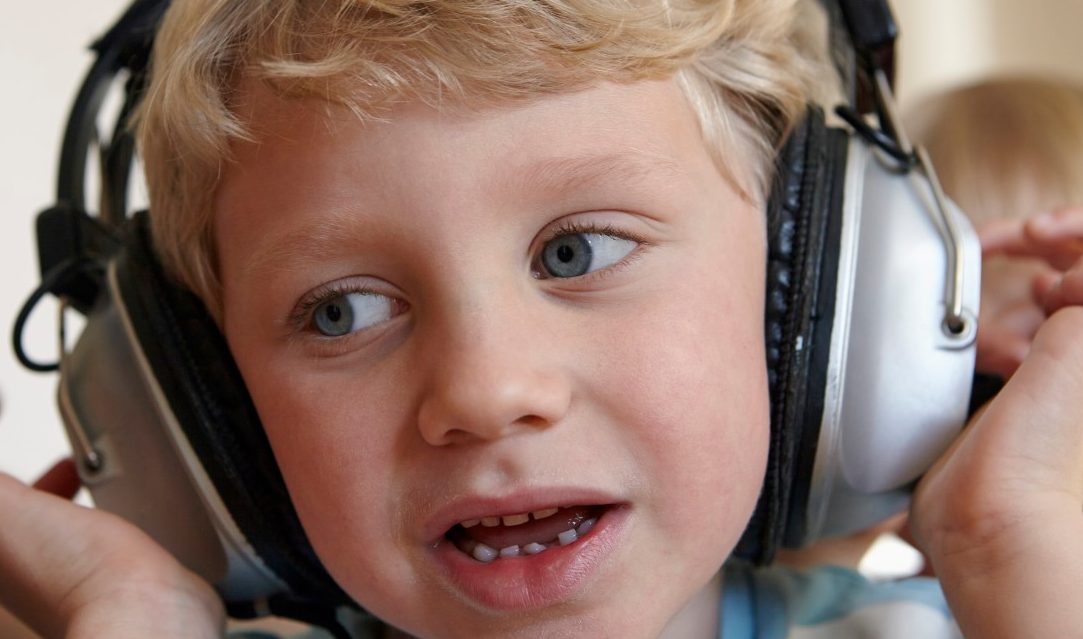 31 Jan 2015 --- Little boy listening to music with headphones --- Image by © Rainer Holz/Westend61/Corbis