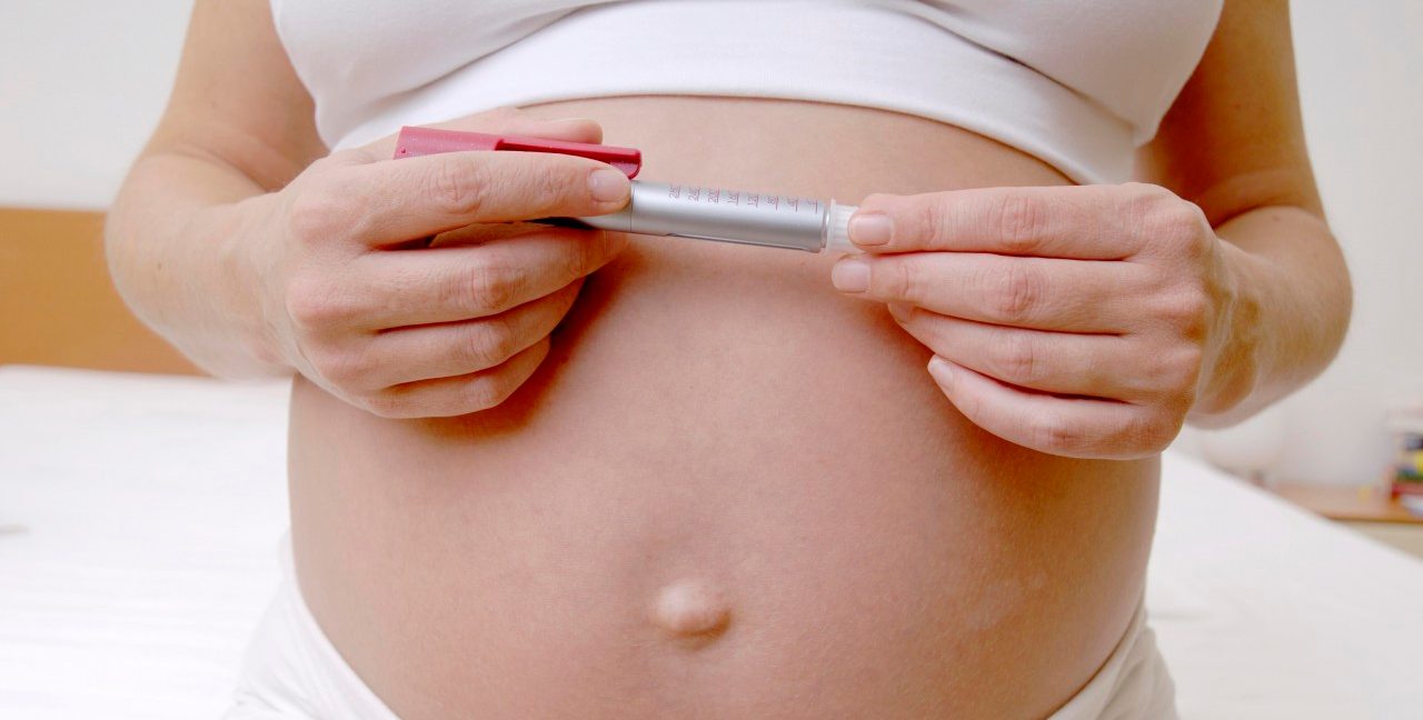 Germany --- Pregnant woman holding insulin pen  --- Image by © Doc-Stock/Corbis