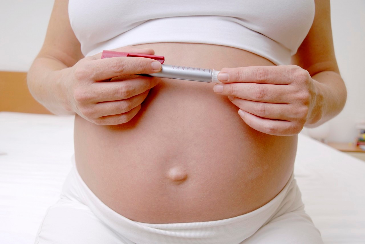 Germany --- Pregnant woman holding insulin pen  --- Image by © Doc-Stock/Corbis